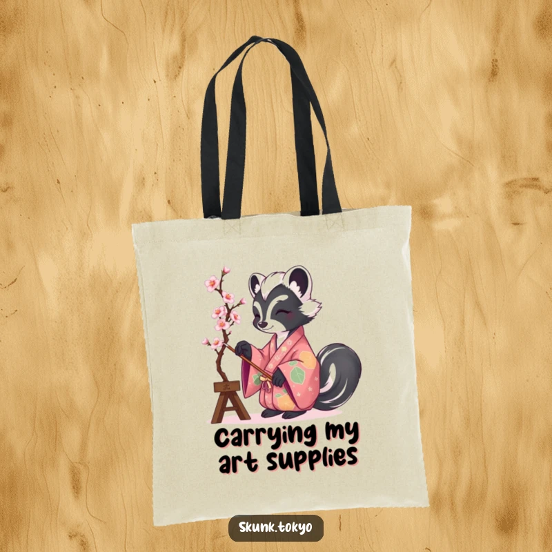 Funny tote bag with a skunk in a vibrant kimono painting cherry blossoms, ideal for carrying art supplies humorously.